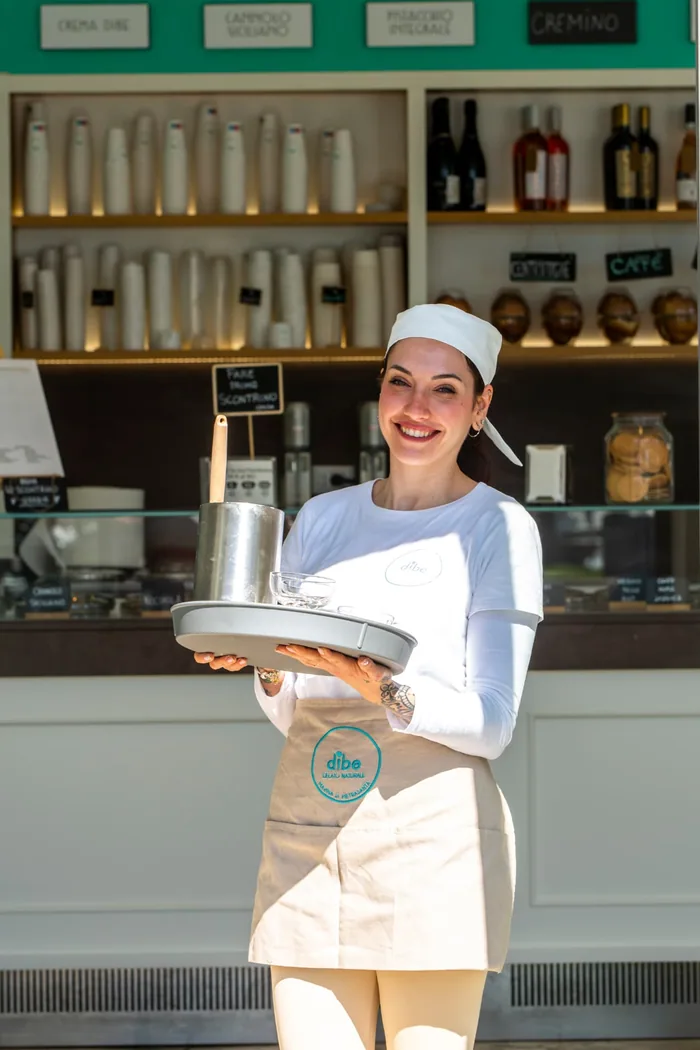 Ragazza del team DiBe con il vassoio davanti alla gelateria